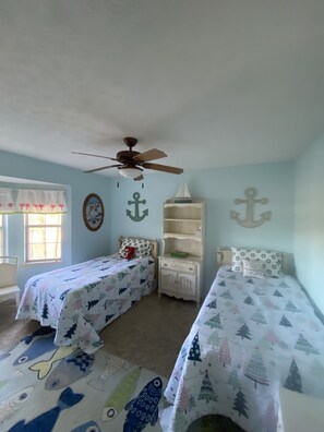 A bedroom with two beds, a ceiling fan, a window with curtains, and wall decorations. - Spacious cabin located in the Blue Ridge Mountains on the beautiful lake Nottely (Blairsville)