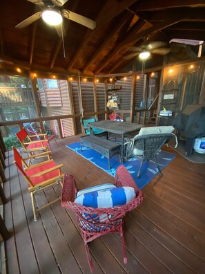 A covered outdoor deck with wooden flooring, wicker furniture, and a ceiling fan. - Spacious cabin located in the Blue Ridge Mountains on the beautiful lake Nottely (Blairsville)