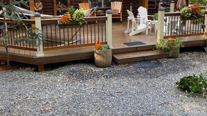 Une cabane en bois dotée d’un porche, d’un espace salon extérieur et d’une allée gravillonnée.