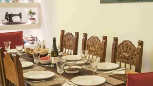 A dining room with a wooden table set for a meal, surrounded by chairs. - Athenian House in Plaka (Athens)