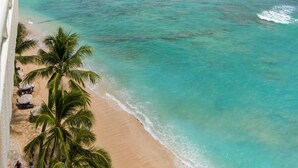 A beach with clear turquoise water, palm trees, and a distant mountain. - A View to Die for! 3 bedroom 3 bath on the sand at Waikiki Beach (Honolulu)