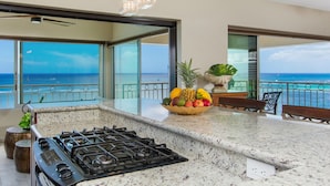 A kitchen with a gas stove, a fruit bowl, and a view of the ocean. - A View to Die for! 3 bedroom 3 bath on the sand at Waikiki Beach (Honolulu)