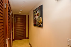 A hallway with a wooden door and a painting on the wall.