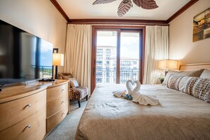 Une chambre d’hôtel avec un lit, une télévision, un bureau et une vue sur la ville par la fenêtre.