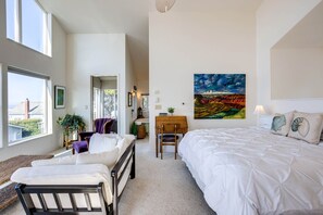 Un dormitorio con cama, escritorio y silla. Una ventana ofrece vistas al exterior.