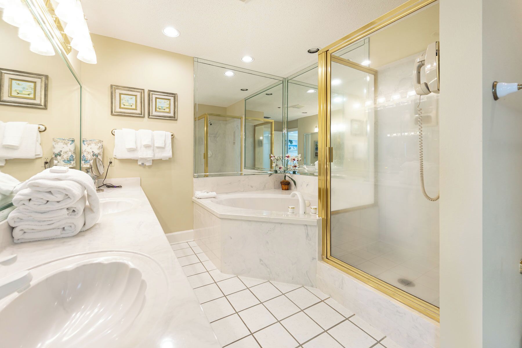 Un baño moderno con una bañera grande, cabina de ducha separada y tocador con espejo.