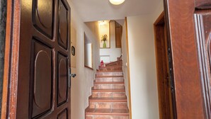 A wooden staircase leading to a landing with a vase of flowers. - Studios Belvi (Kotor)