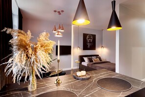 Una sala de estar moderna con una mesa de centro de mármol, un jarrón decorativo y un sofá con cojines.