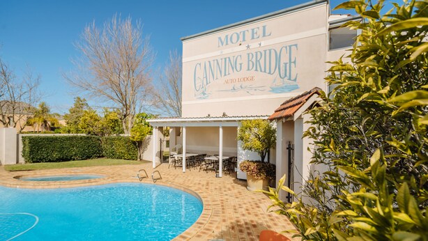 Un motel chiamato Canning Bridge con piscina e area salotto all'aperto.