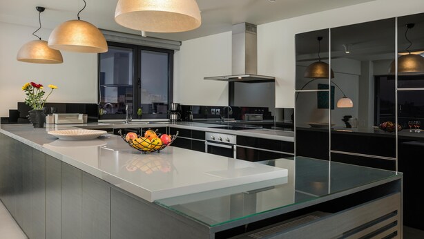 A modern kitchen with a large island, stainless steel appliances, and pendant lighting. - Spring Apartments (Chania)