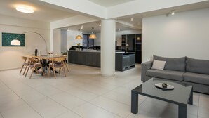 A spacious living area with a dining table, sofa, and a coffee table. - Spring Apartments (Chania)