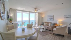 A living room with a dining area, a ceiling fan, a sofa, and a view of the outdoors. -  New 1BR/1BA Luxury Beachfront Vacation Rental! Sleeps 6! Near Pier Park! (Panama City Beach)