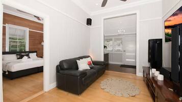 A modern living room with a sofa, a coffee table, and a television.