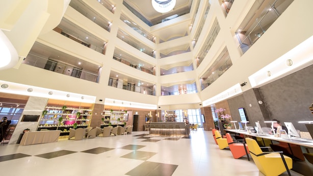 A multi-level atrium with a central open space, multiple seating areas, and a bar/lounge with a view of the lower levels. - AJ Hotel Hsinchu (Zhubei)