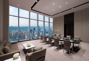 Un comedor moderno con vistas a la ciudad, amplias ventanas y mobiliario contemporáneo.
