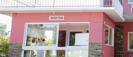 A building with a reception area, stone facade, and a balcony.