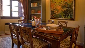 Un coin repas avec une table en bois, des chaises et un tableau accroché au mur.