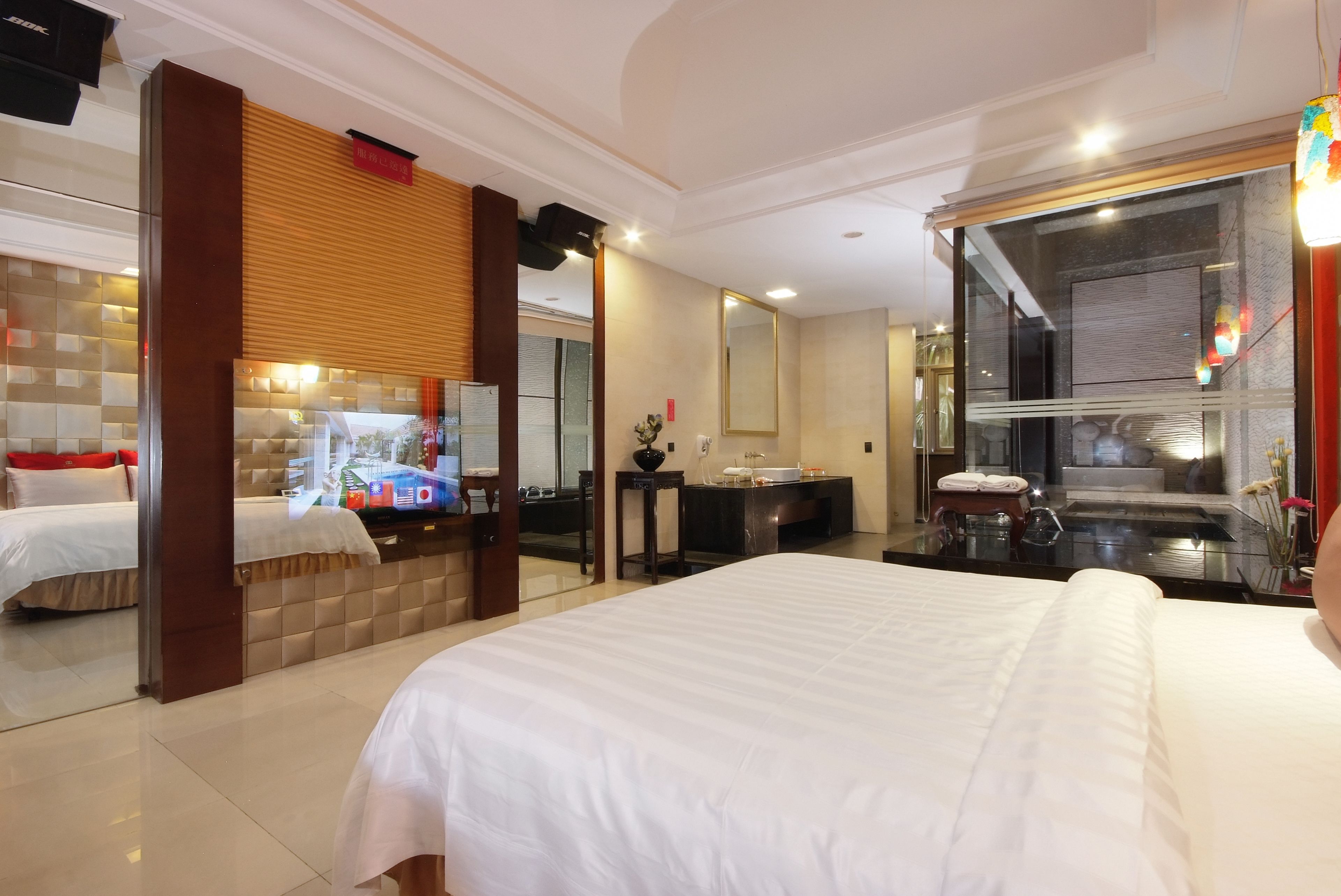 Hotelkamer met een groot bed, een bureau, een spiegel en een badkamer met een douchecabine.