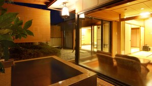 A modern building with a glass entrance, a hot tub, and a wooden deck. - Hotel Danrokan (Kofu)