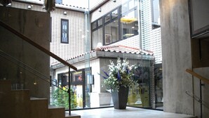 A staircase leading to a second floor with a potted plant on the landing. - Hotel Danrokan (Kofu)