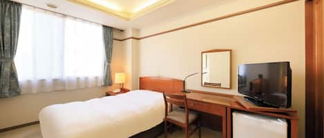 A hotel room with a bed, desk, chair, television, and a small refrigerator.