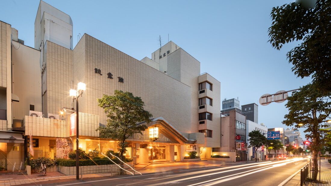 A hotel with a modern facade, a prominent entrance, and a street view with traffic.