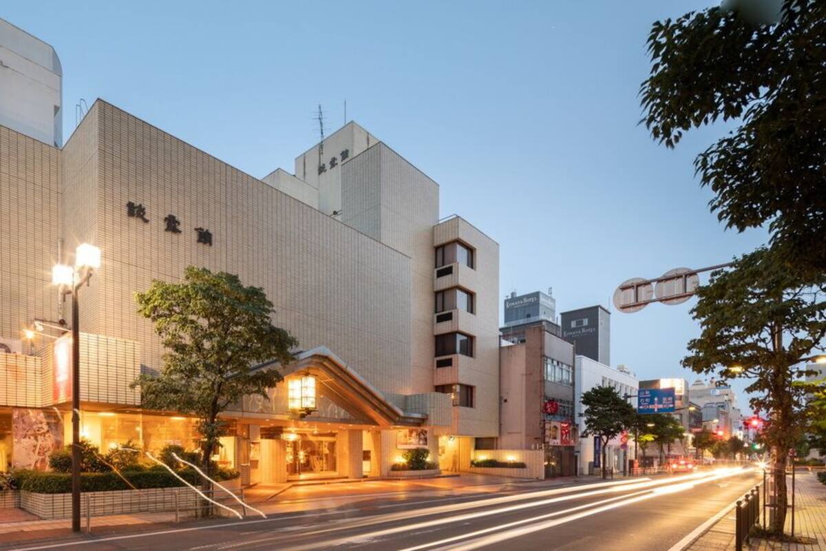 Ein Hotel mit moderner Fassade, einem markanten Eingang und Straßenansicht mit Verkehr.