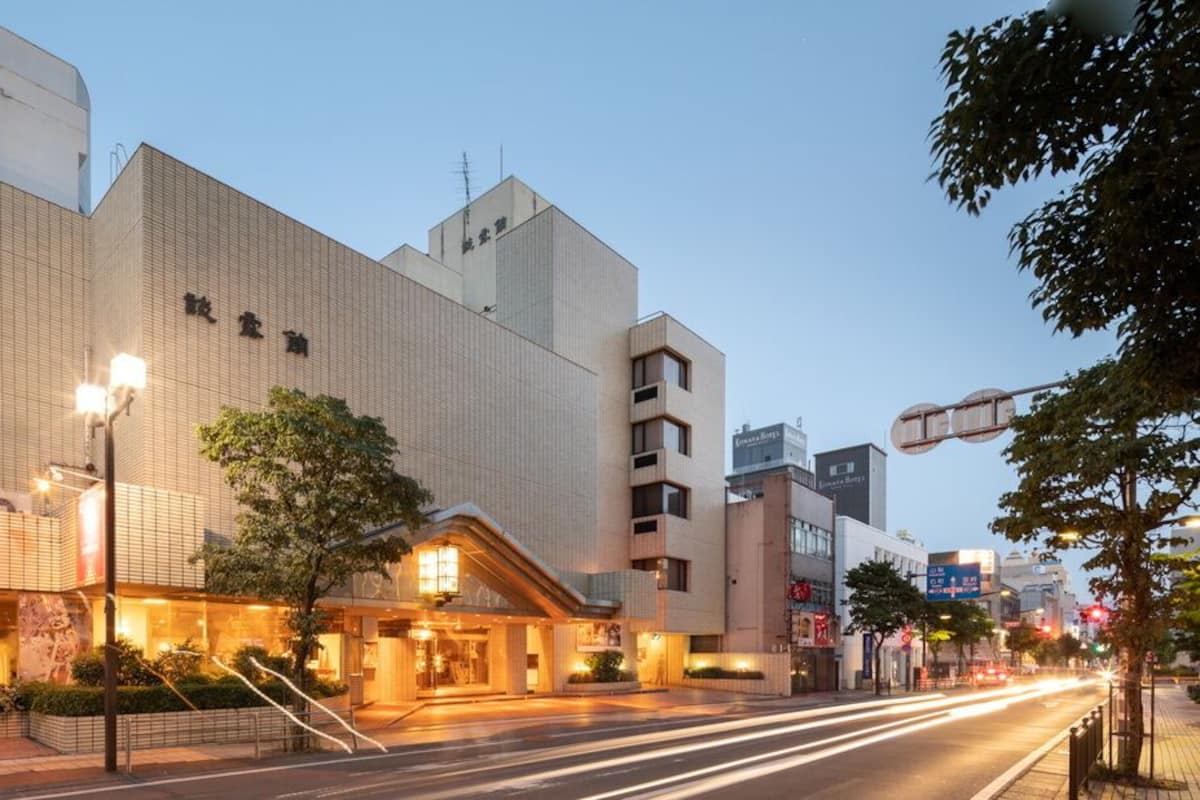 A hotel with a modern facade, a prominent entrance, and a street view with traffic.