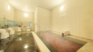 Un área de spa con un jacuzzi, ducha y un inodoro.