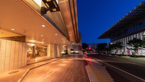 A modern building with a tiled facade and a paved entrance area. - Hotel Danrokan (Kofu)