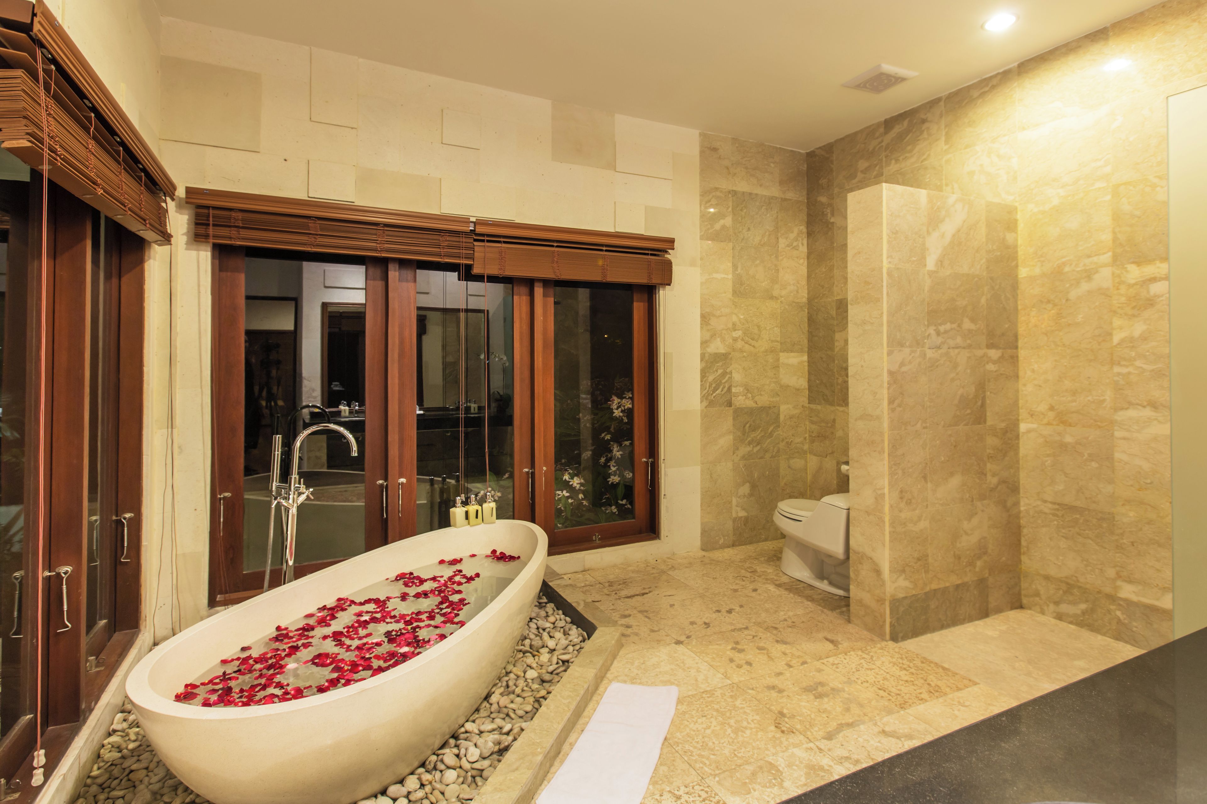 Une salle de bain moderne avec une baignoire sur pieds, un espace douche et des toilettes.