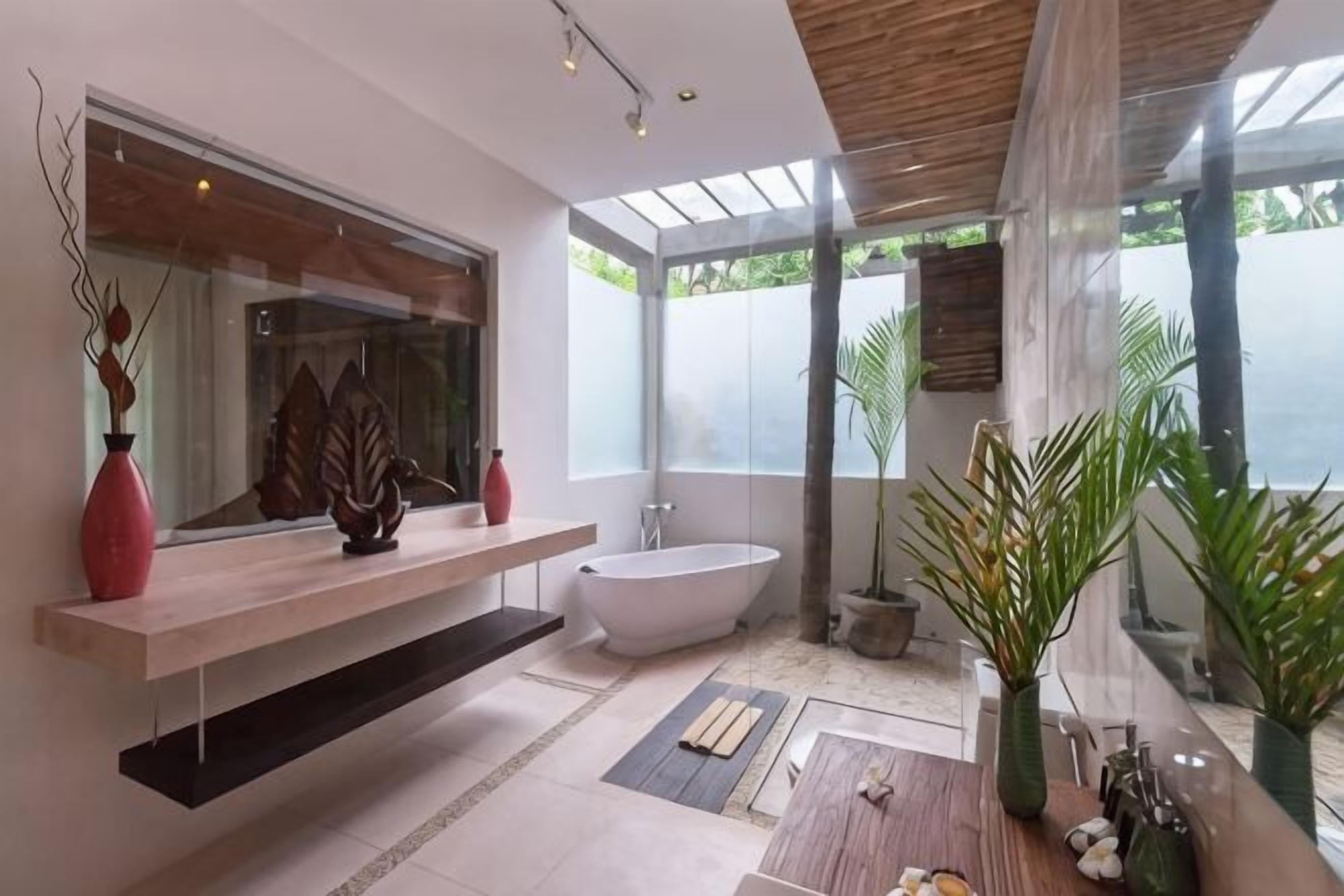A modern bathroom with a freestanding bathtub, a large mirror, and a wooden vanity.