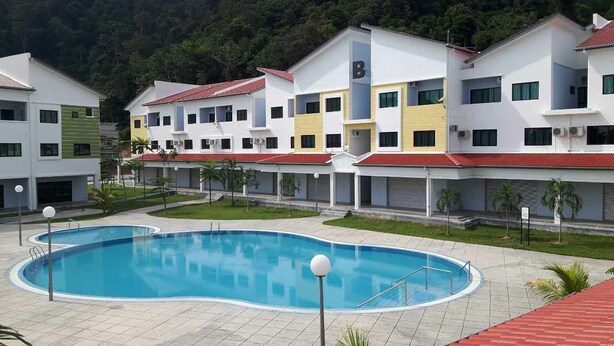Un hotel moderno con piscina, varios pisos y un edificio de techo rojo.