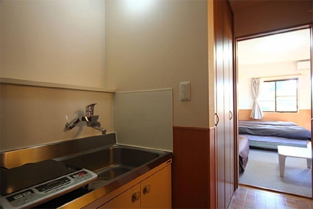 A compact kitchen with a sink, a digital scale, and a window.