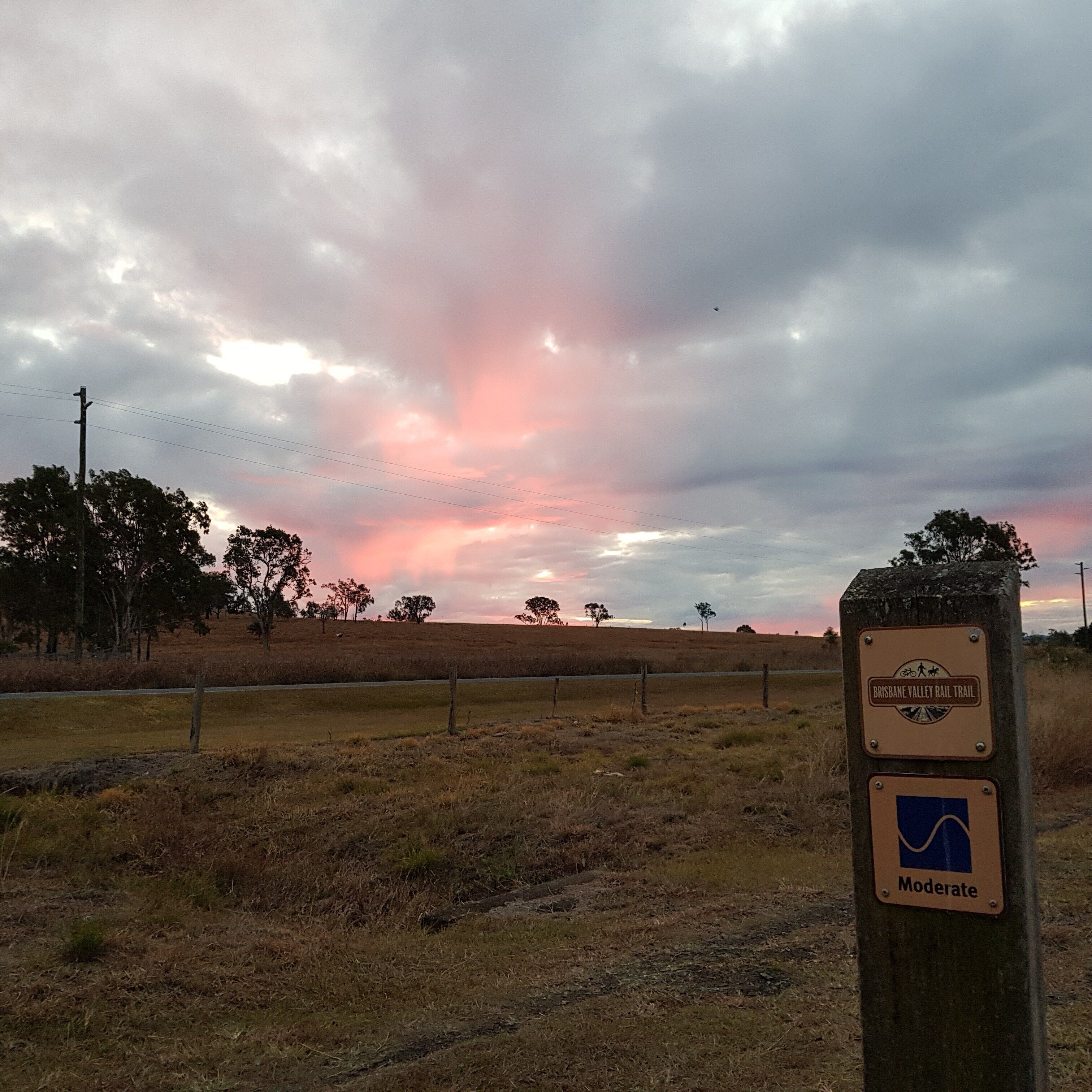 A sign for the Brisbane Valley Rail Trail with a moderate difficulty rating.