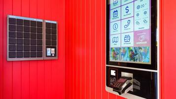 Een rode muur met een digitaal scherm en een klein raam.
