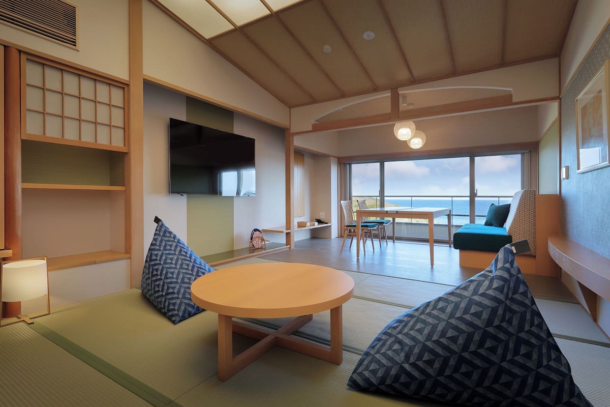Una habitación tradicional japonesa con suelo de tatami, una mesa de madera baja y cojines.