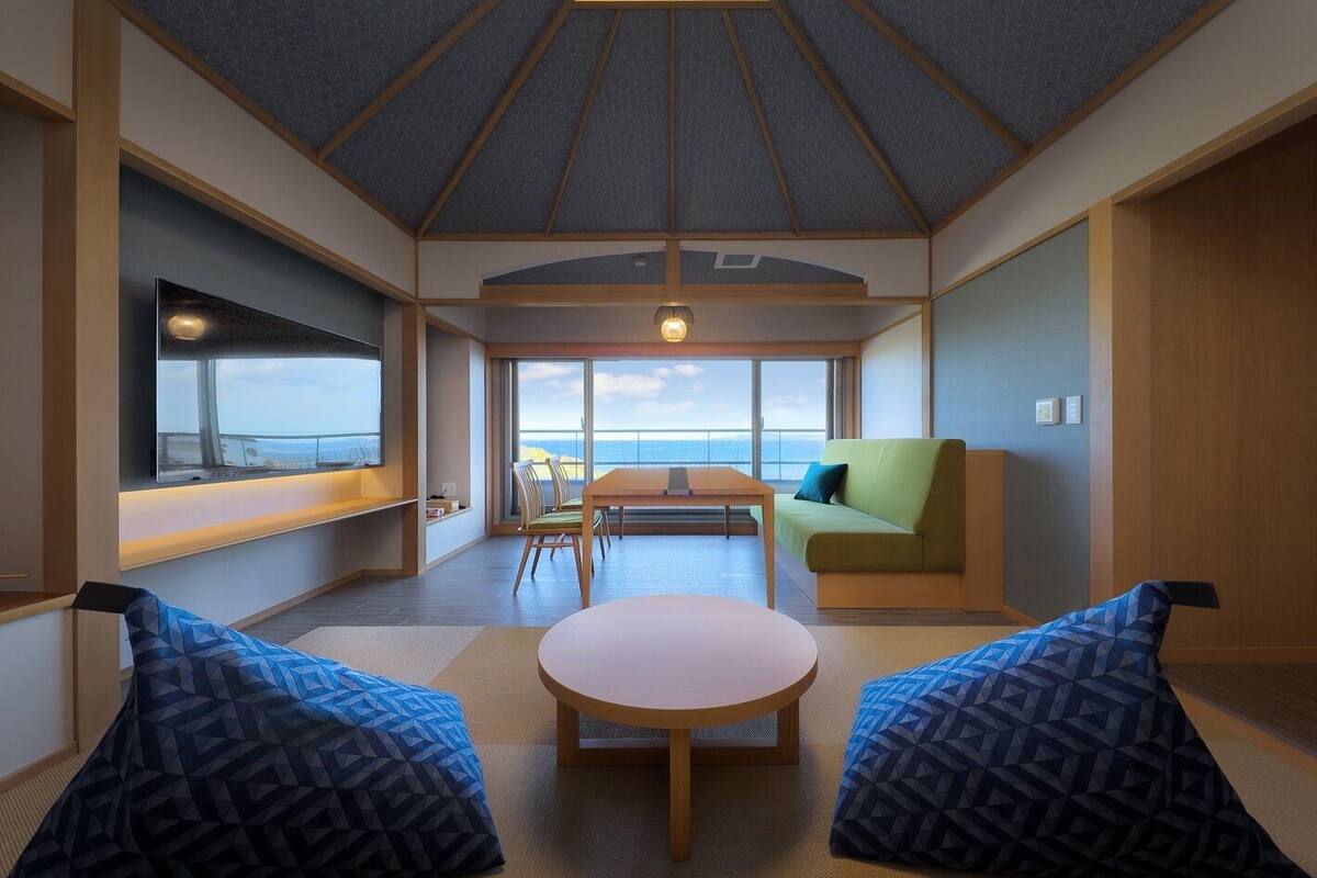 Un interior moderno con un ventanal grande, una zona de comedor y un conjunto de asientos.