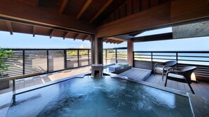 A hot tub with a view of the ocean, wooden deck, and outdoor seating. - Hotel Sunosaki Kazenosho (Tateyama)