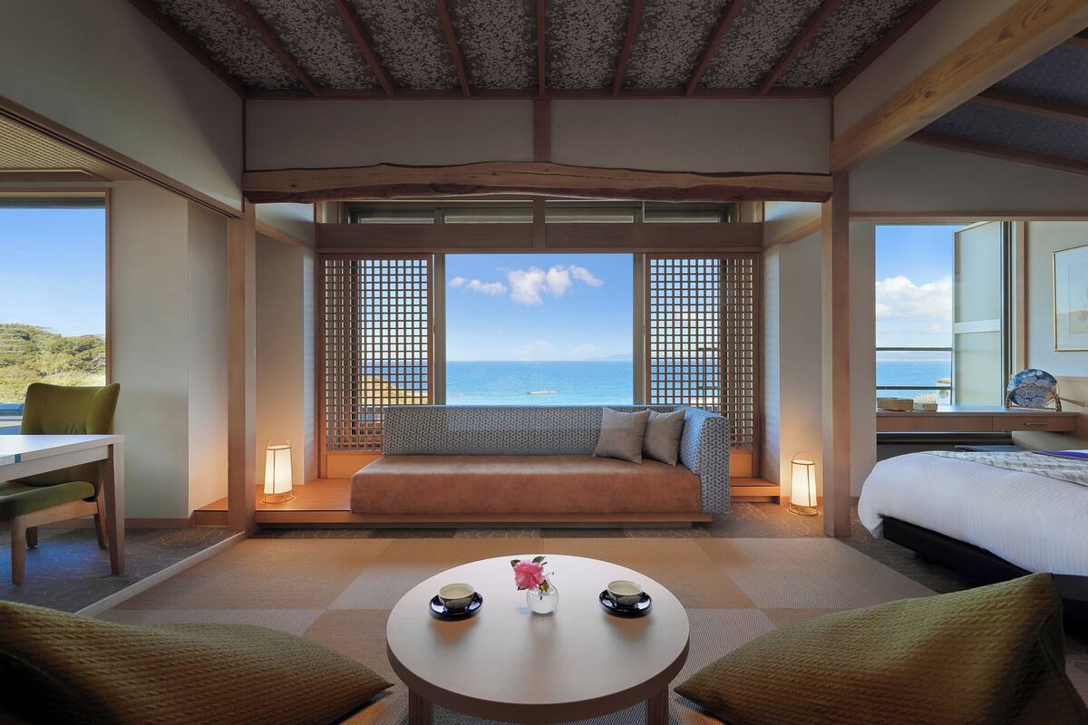 Una habitación con sofá, una mesa de comedor y vista al mar.