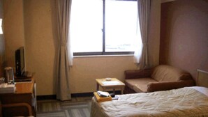 A hotel room with a bed, a desk, a chair, and a small table. - Mitsui Kanko Hotel (Rebun)