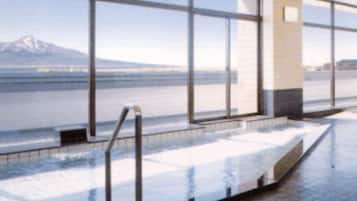 A pool area with large windows and a view of a mountain.