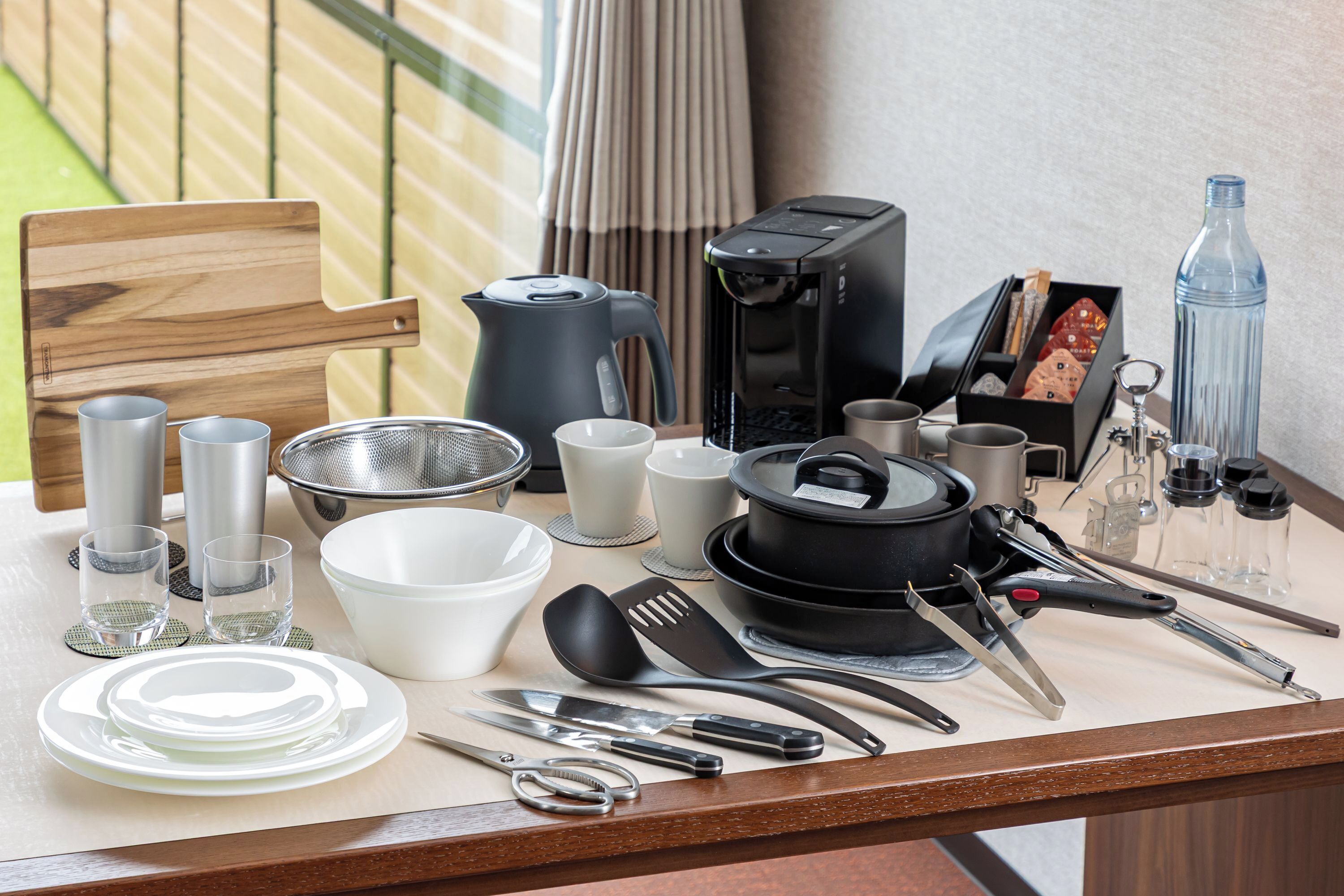 Uma bancada de cozinha com vários utensílios, panelas e uma cafeteira.