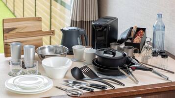 Uma bancada de cozinha com vários utensílios, panelas e uma cafeteira.