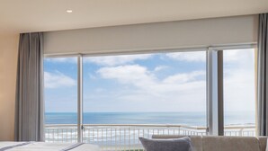 Habitación de hotel con un amplio ventanal que ofrece vistas al océano.