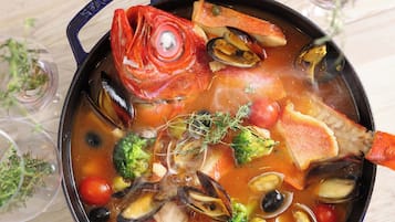 A pot of seafood stew with various ingredients like fish, mussels, and vegetables.