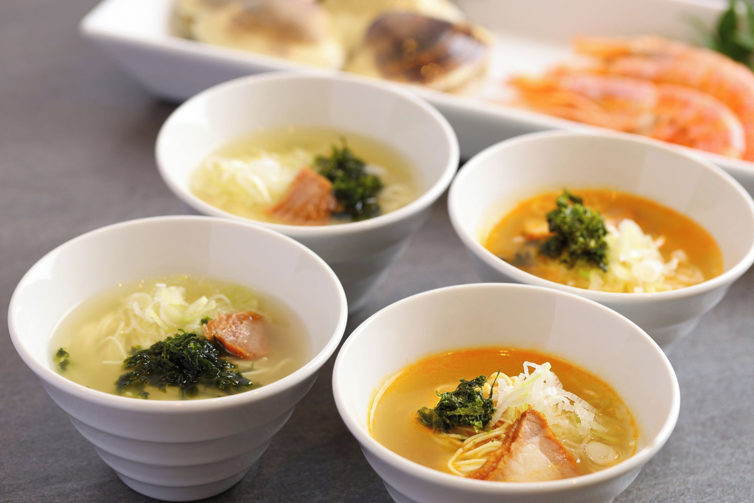 Four bowls of soup with different ingredients.