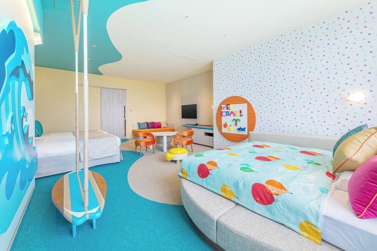 A modern hotel room with a large bed, a desk, and a sofa.