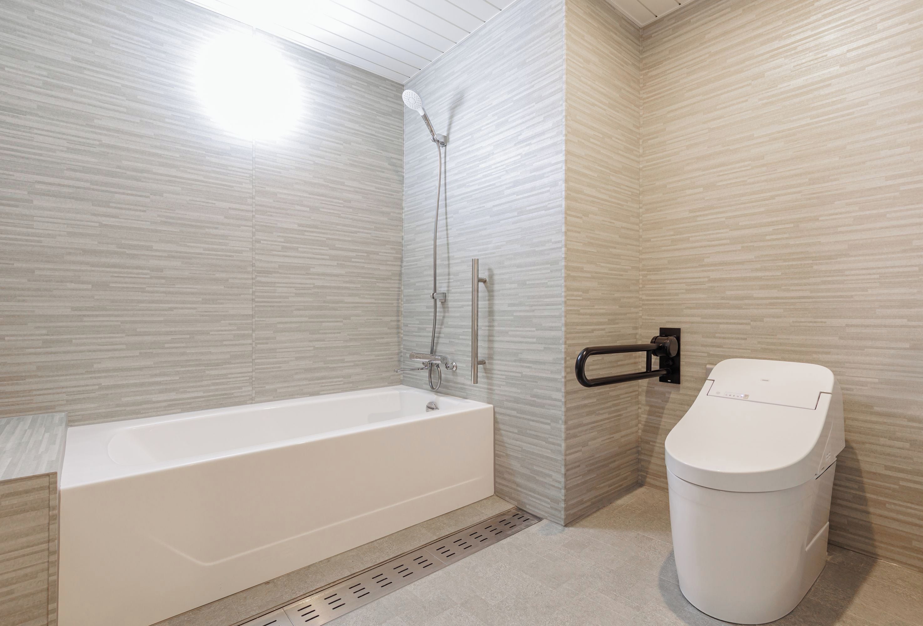 A bathroom with a white bathtub, a shower, and a toilet.