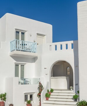 Stylish two-story building with a minimalist design, featuring a central archway and a small balcony.